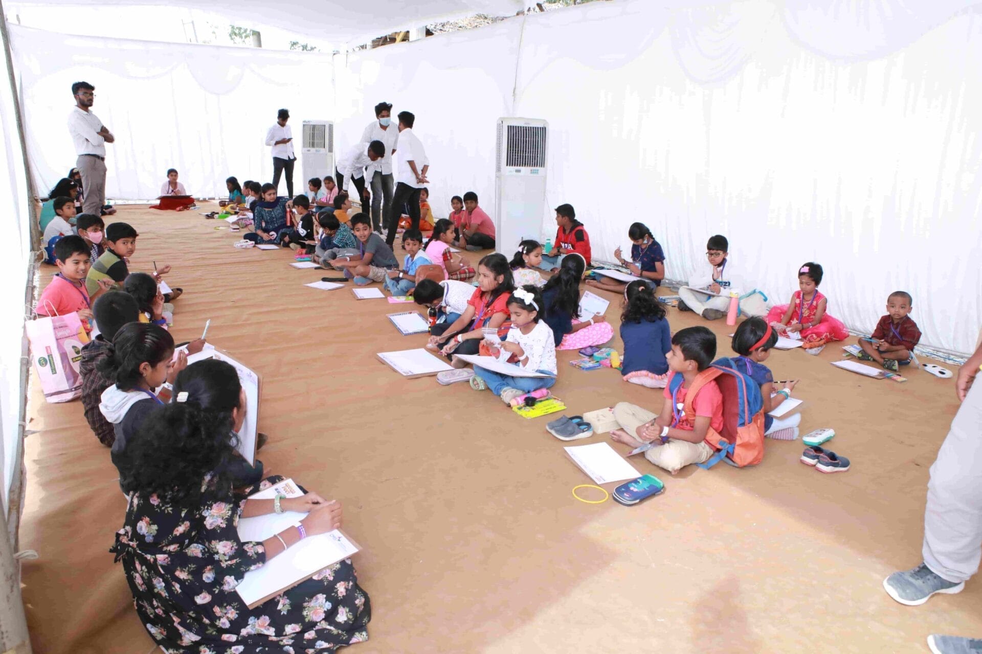 Children sitting row-wise participating in a drawing competition.