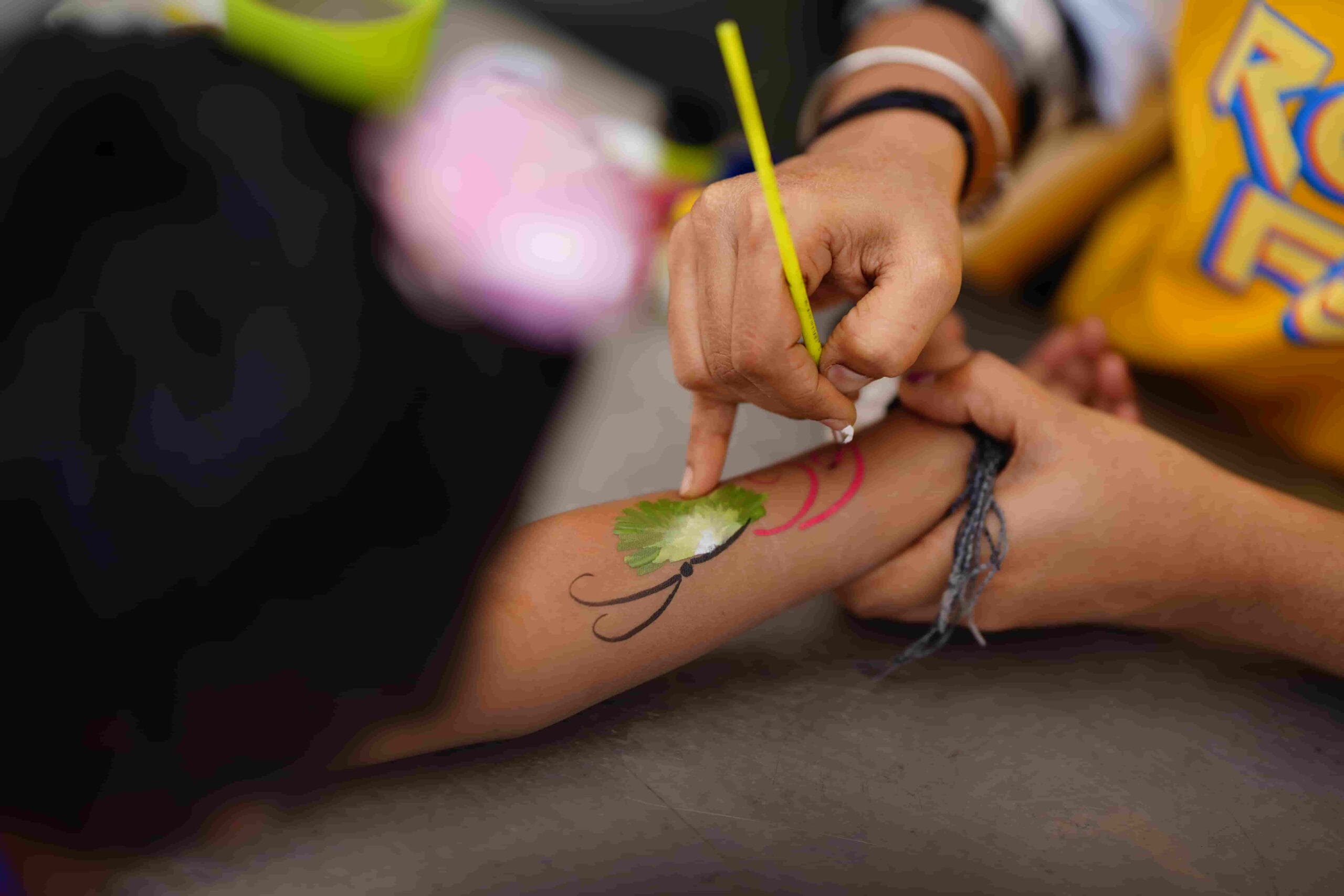Students getting their hands painted with designs.