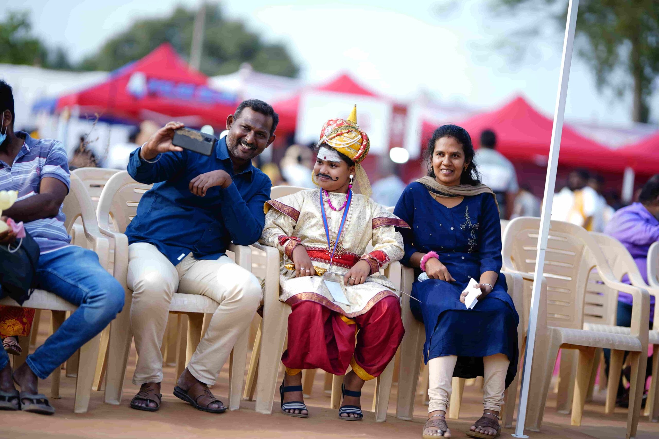 Happy parents posing for a selfie with their child in costume.