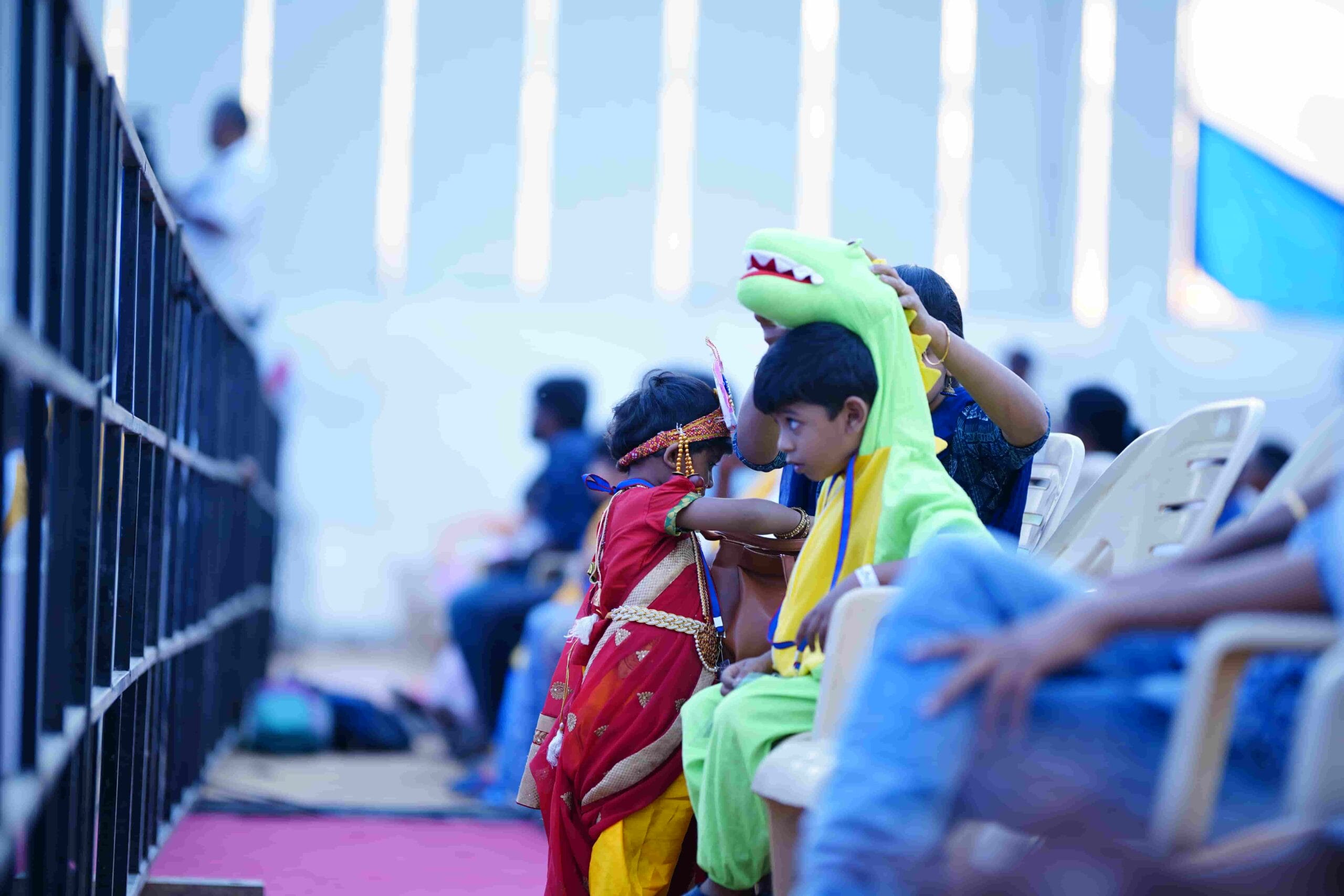 The parent adjusting the costume of a little student with a dino make-over.