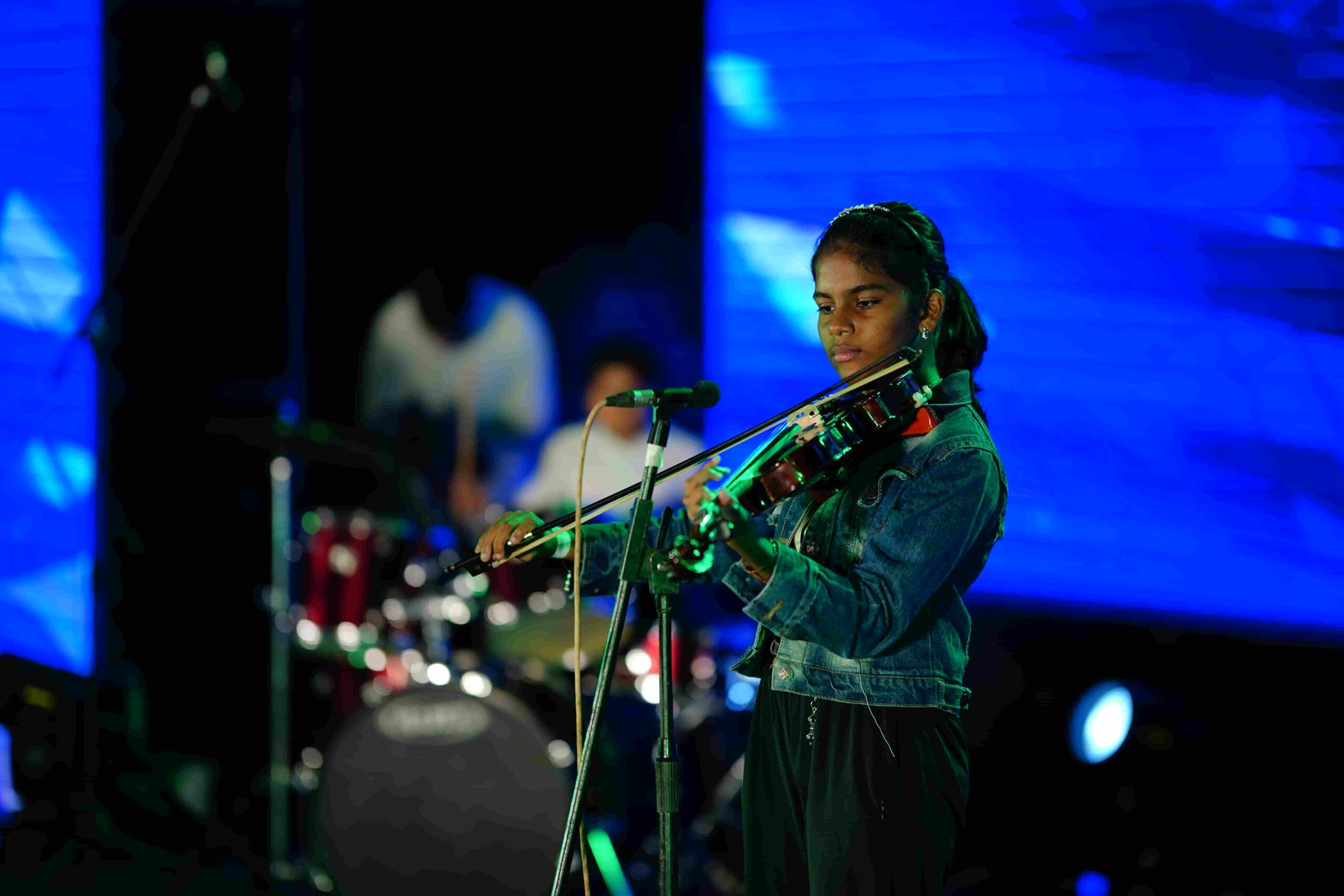 Image of CMIS student giving a violin performance on stage.
