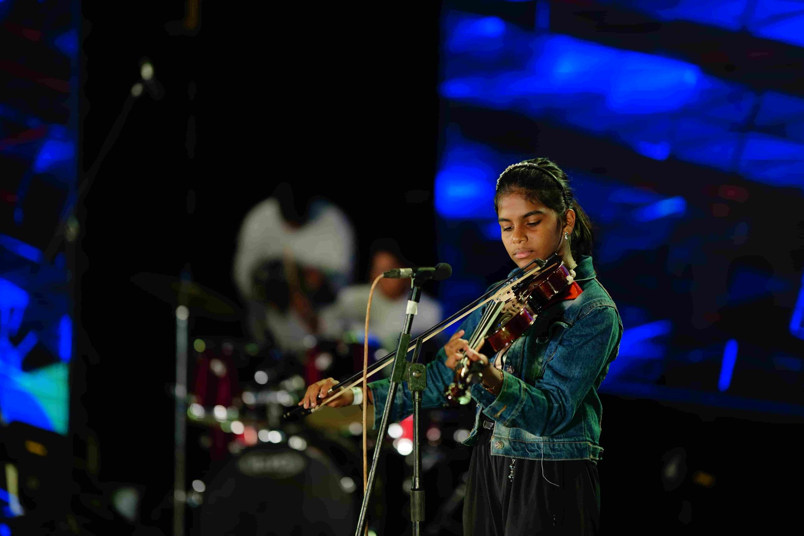 Image of Chandramari International School student giving a violin performance on stage.