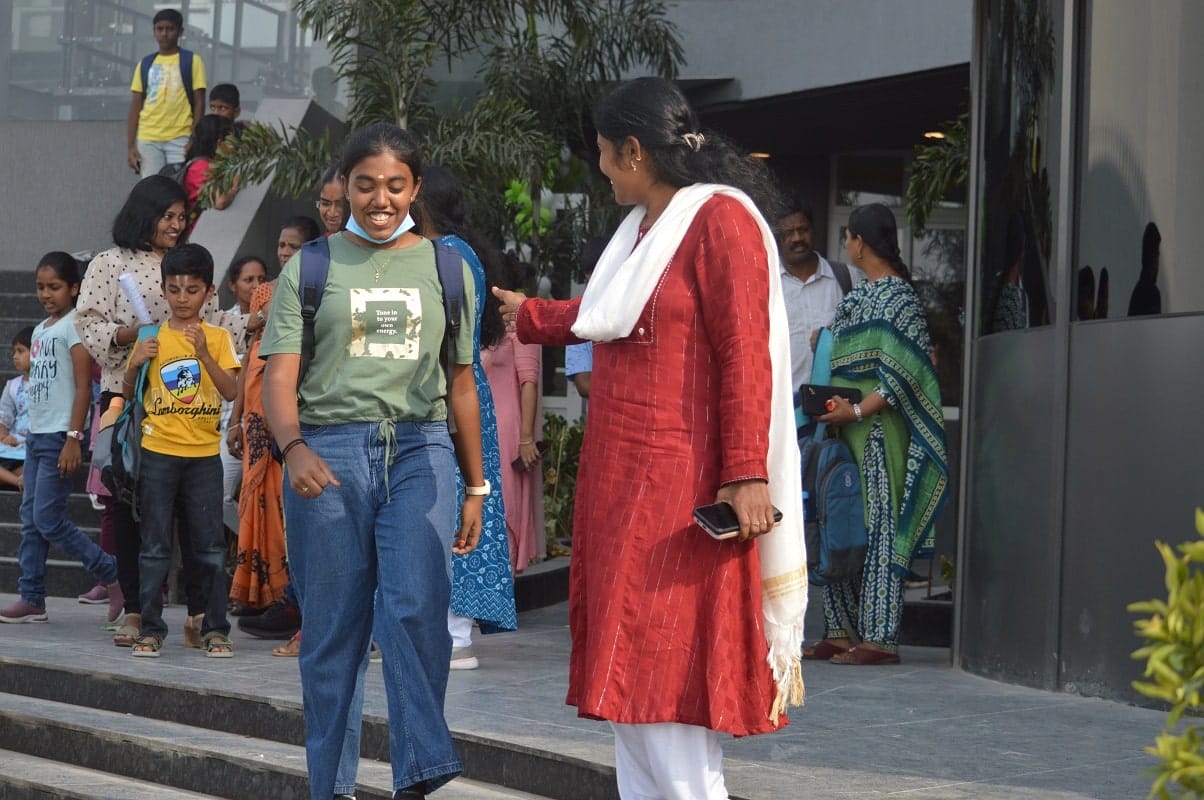 A happy student leaving the school with her parent.