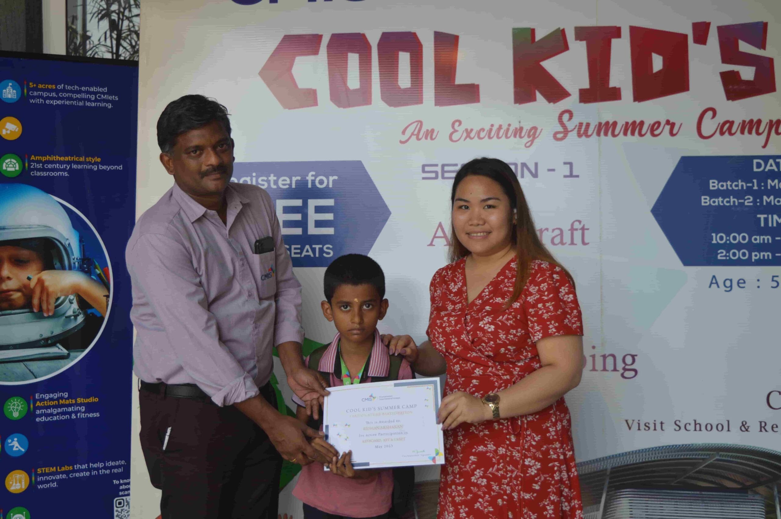 CMIS school boy is awarded with a certificate at the summer camp.