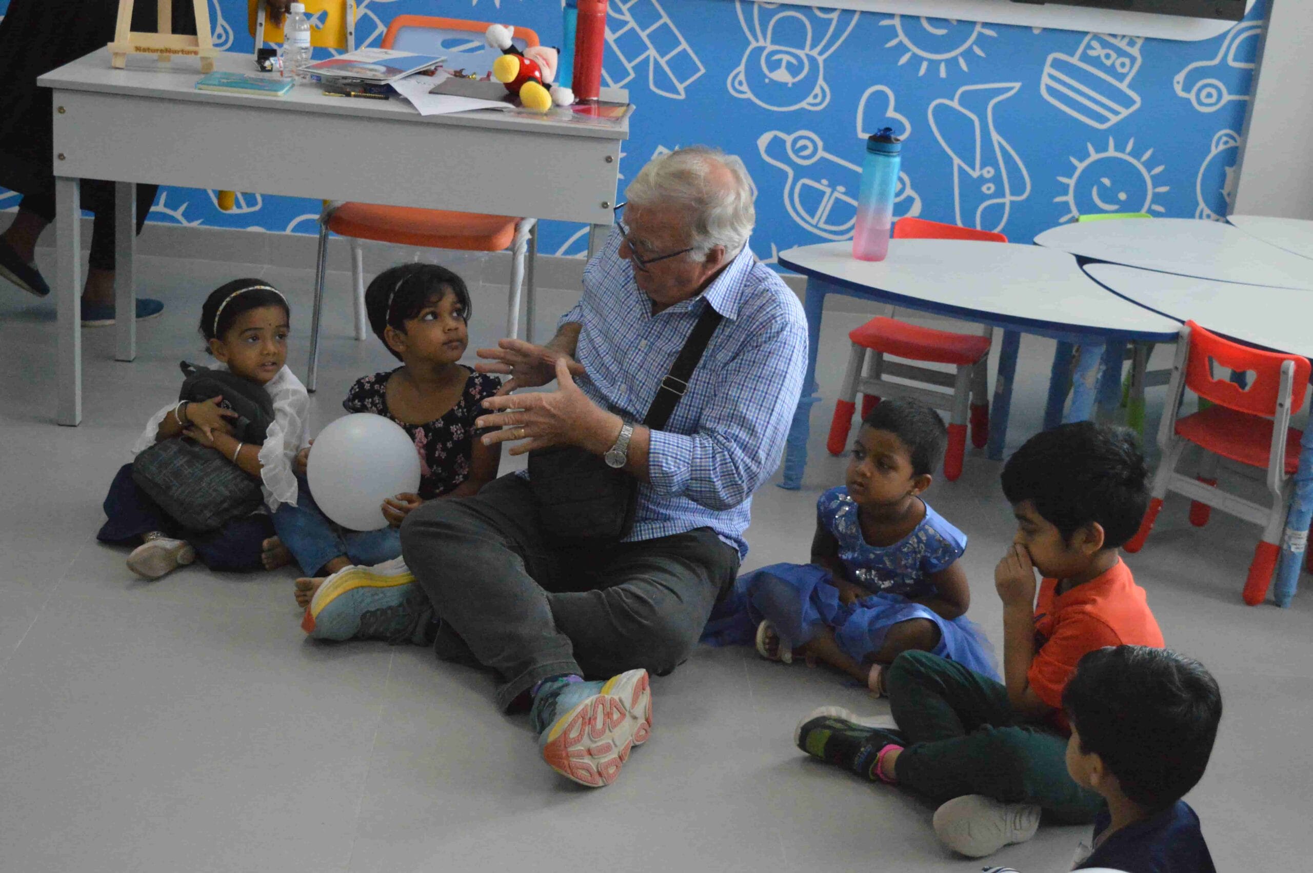 A visitor joyfully interacting with young children.