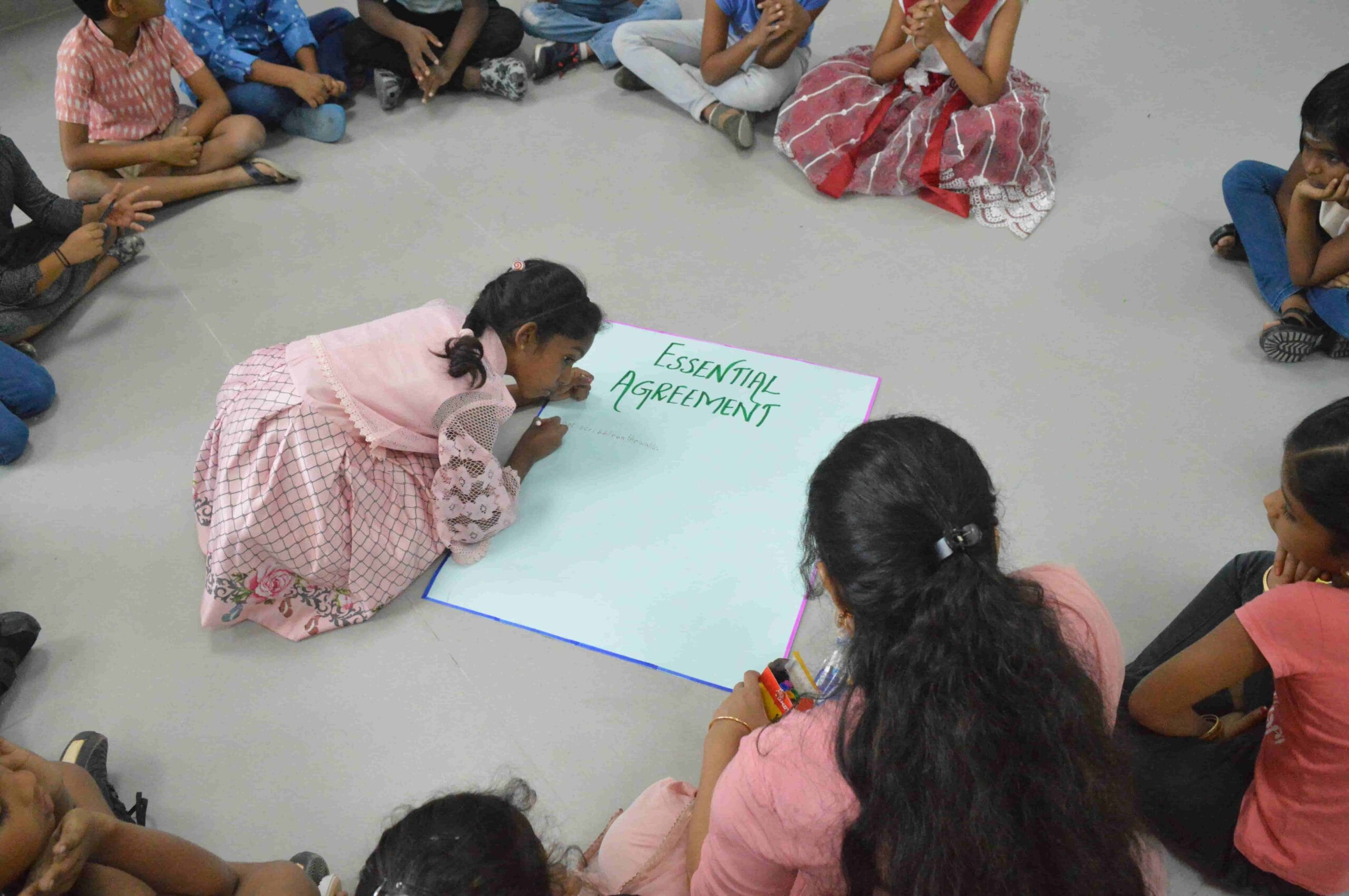 Kids composing the essential agreement together.