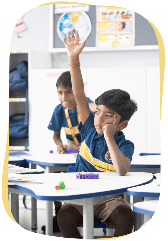 A student with his hands up, seeks assistance.