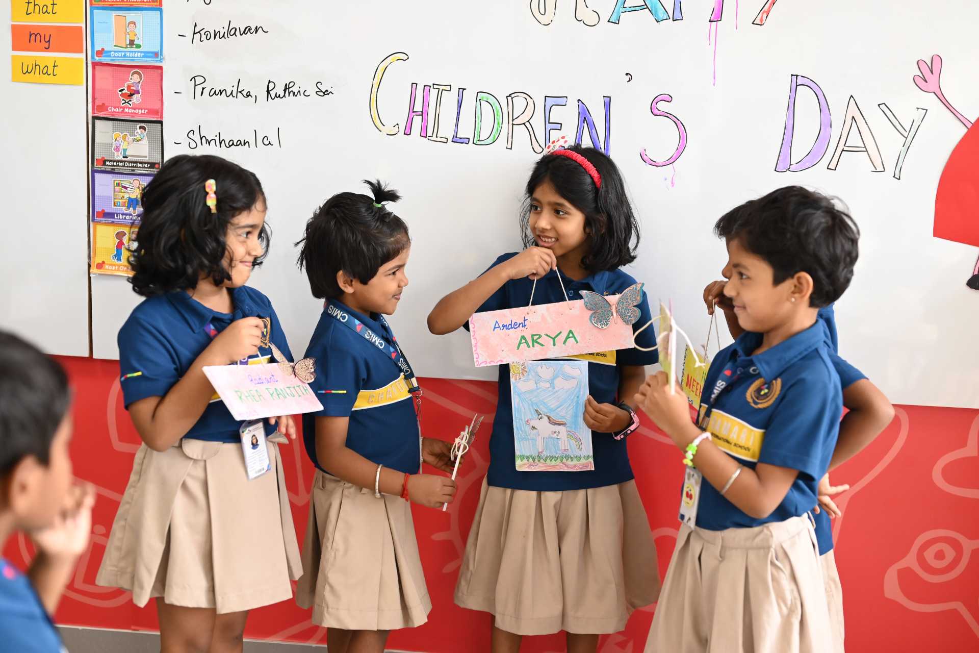 Happy students displaying their drawings and crafts during the Children's Day celebration.