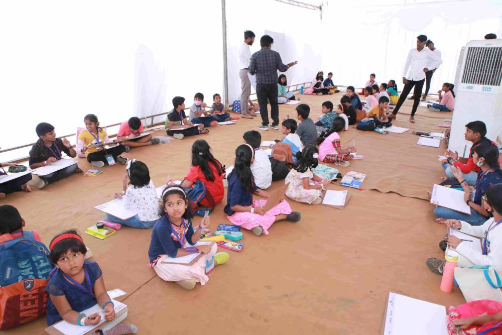 Instructors monitoring the children in the drawing competition.