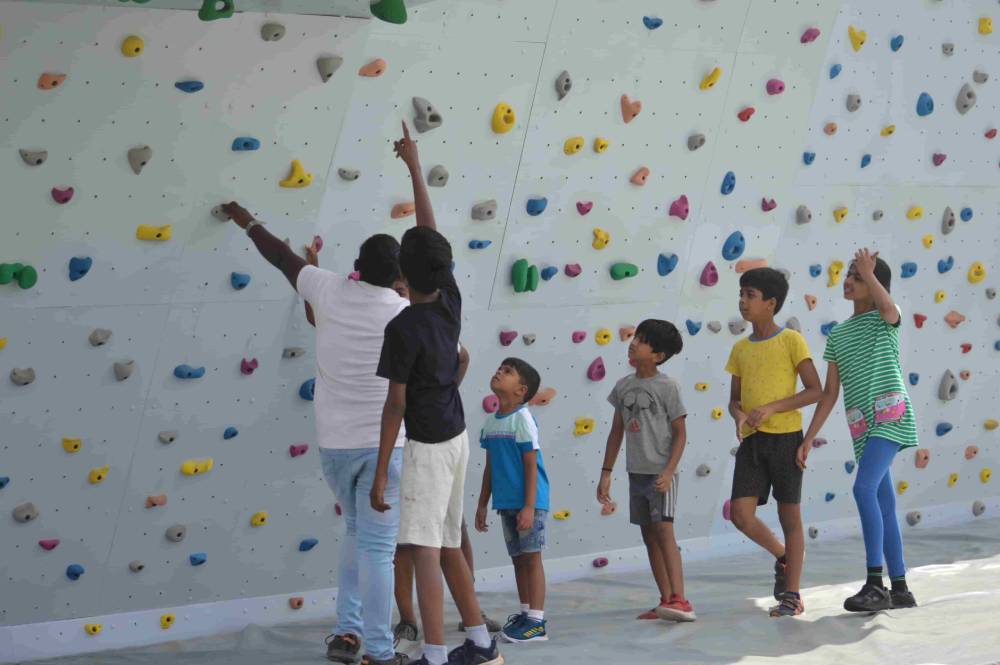 Small boys at wall climbing at CMIS summer camp.