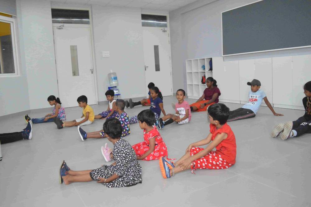 Students doing warmup before dance practice at CMIS.