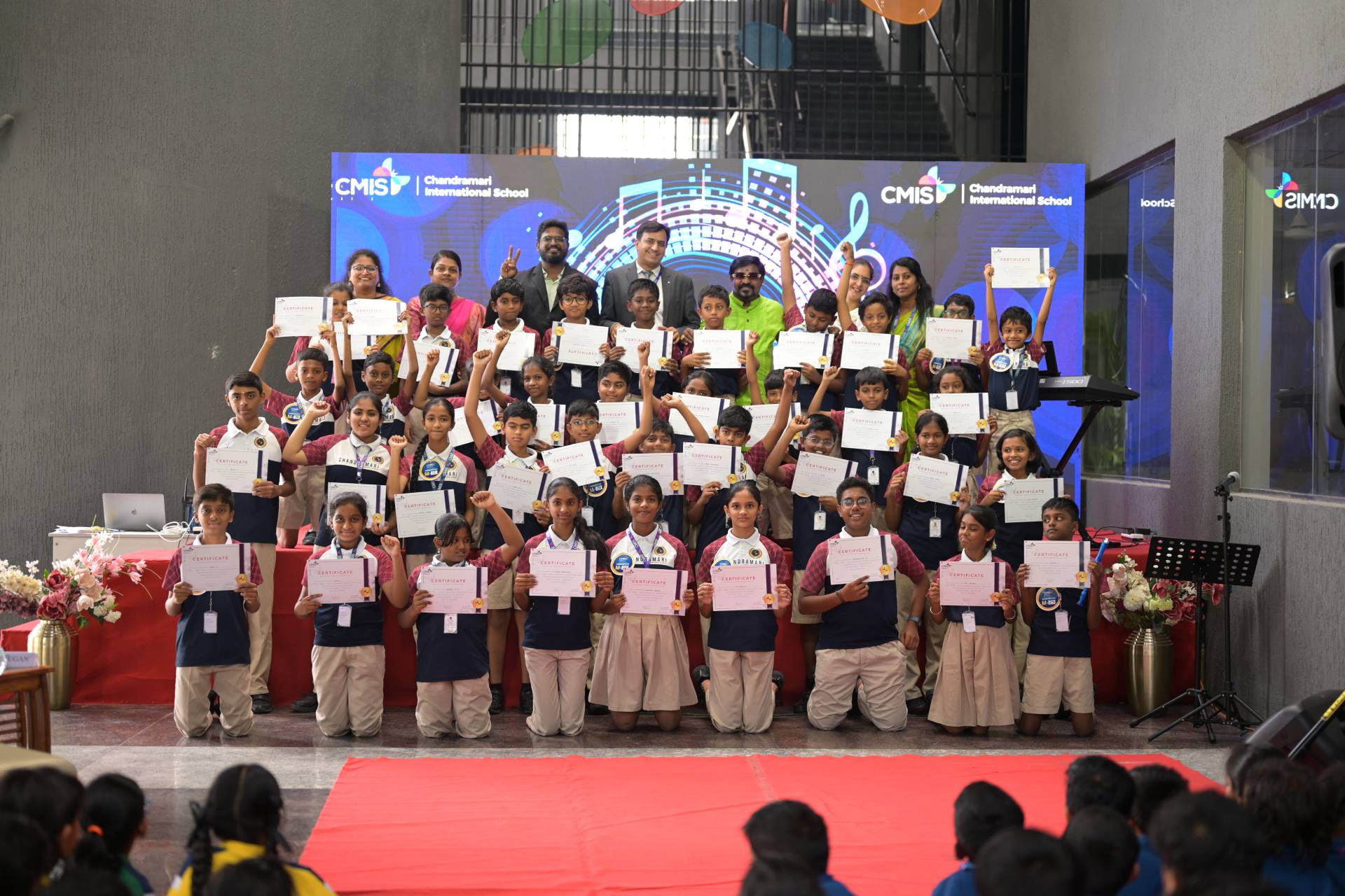 A group of students, diverse in appearance, proudly holding certificates after a music audition.