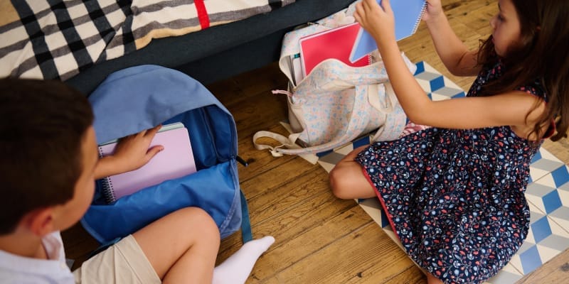 Children carefully pack their school bags, demonstrating a sense of responsibility.